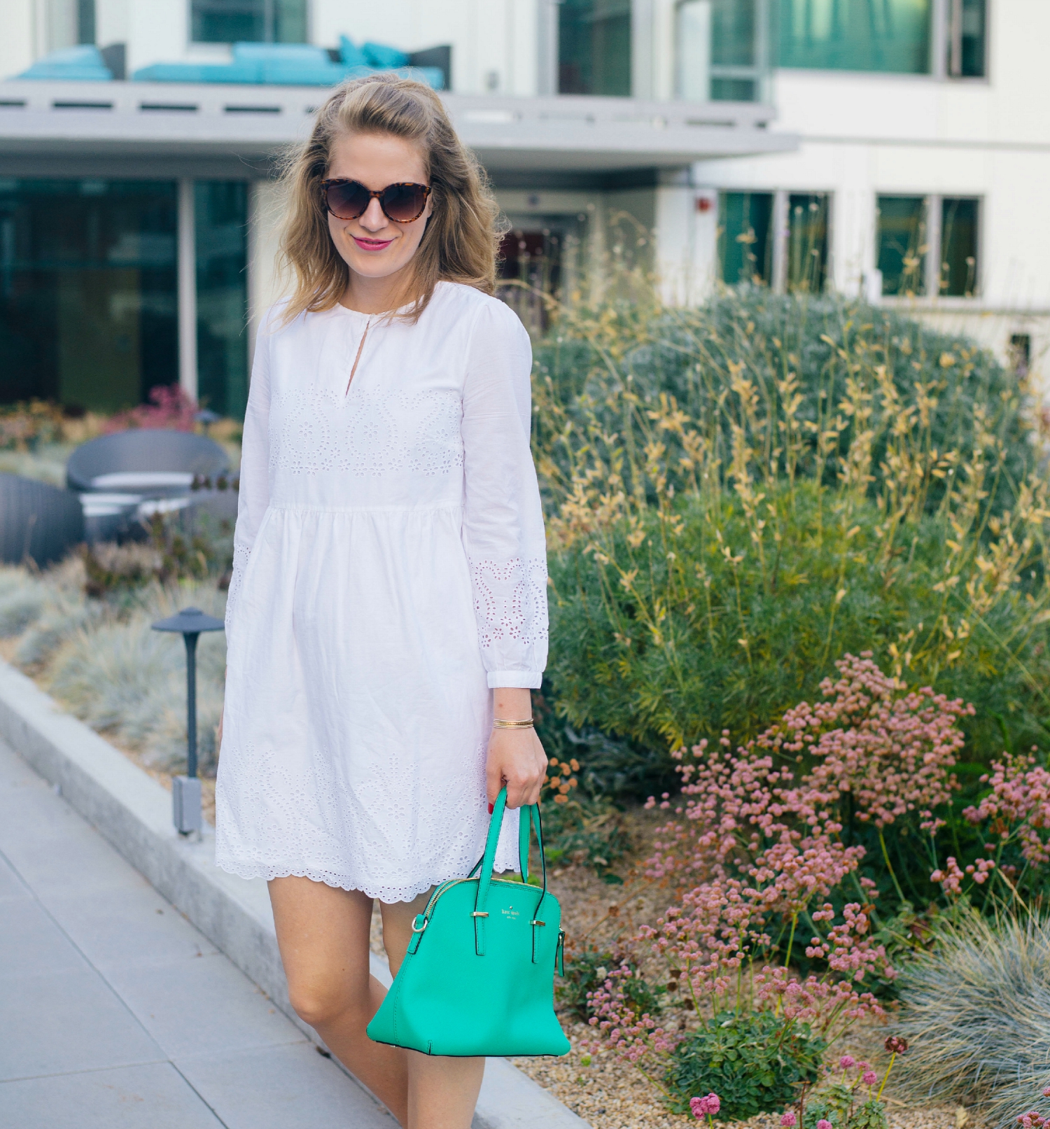 White Eyelet Dress with Green Kate Spade Bag.