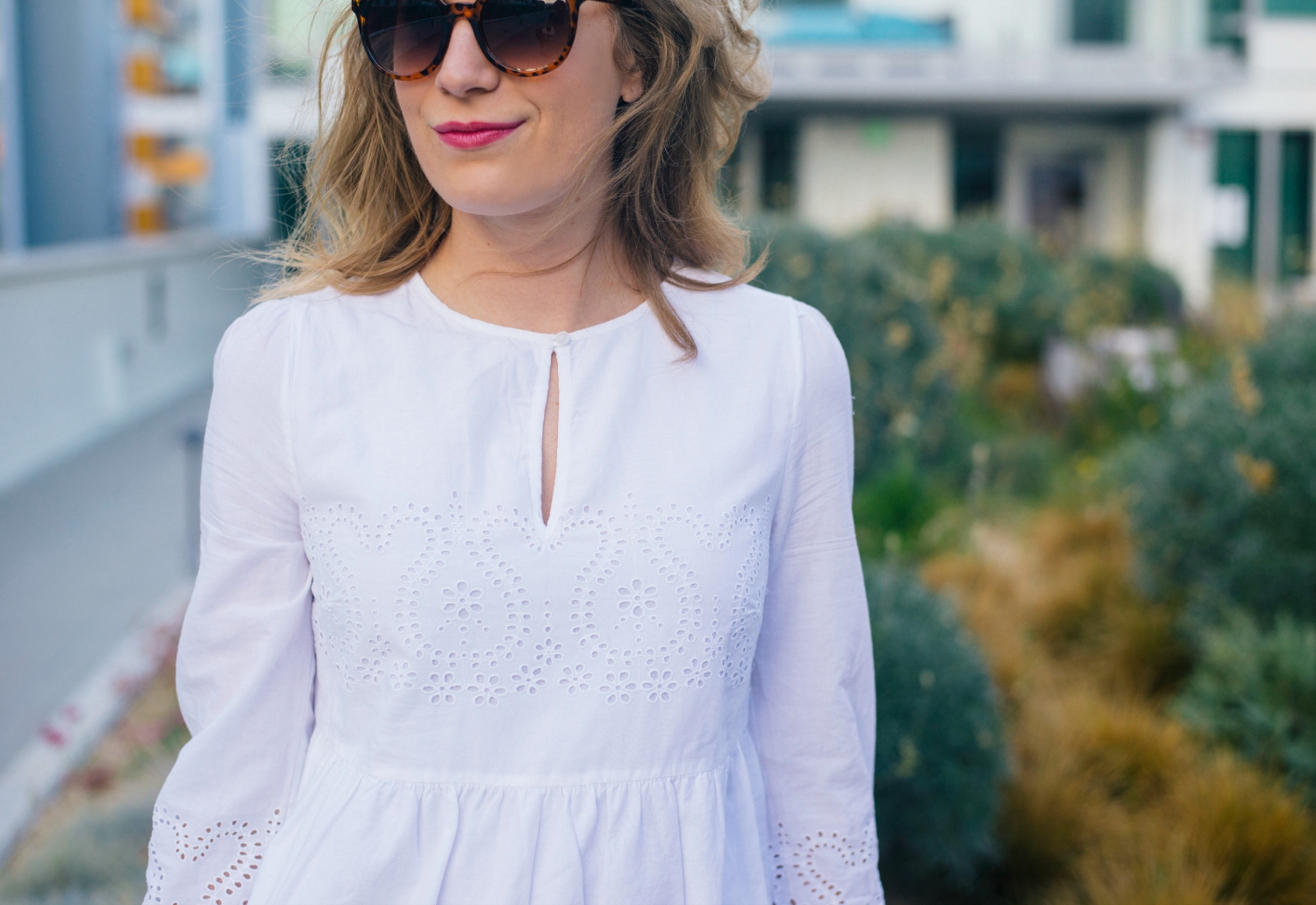 White Eyelet Dress with Green Kate Spade Bag.